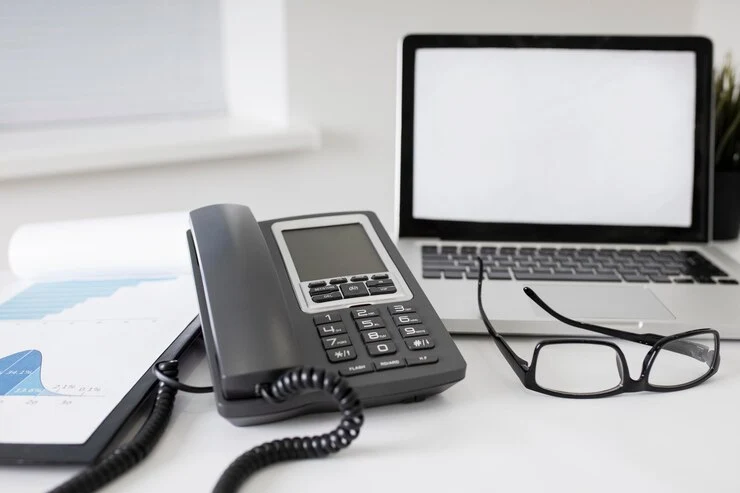 Office workspace with a VoIP desk phone | Vopro Tel
